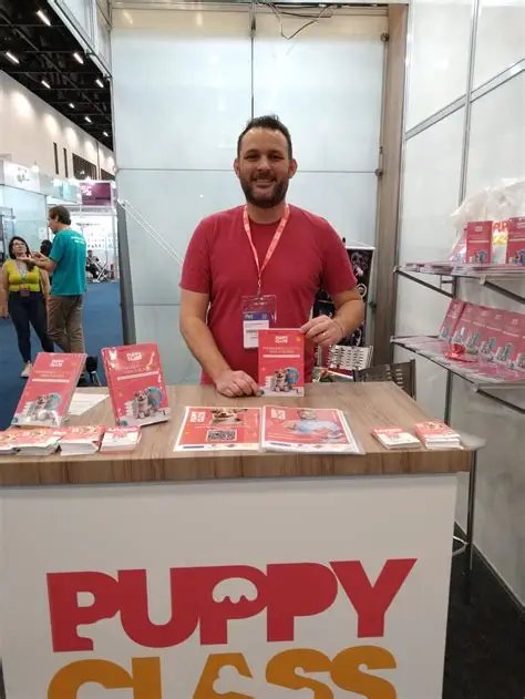 João Marcel Camargo no estande da PuppyClass Brasil, com os livros sobre a mesa
